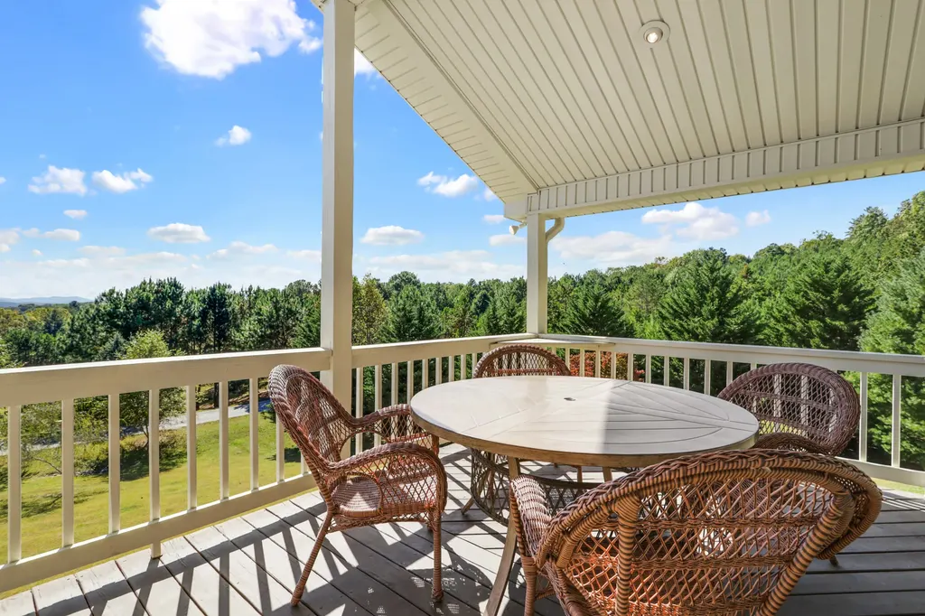 Covered deck with a round table and the mountains beyond