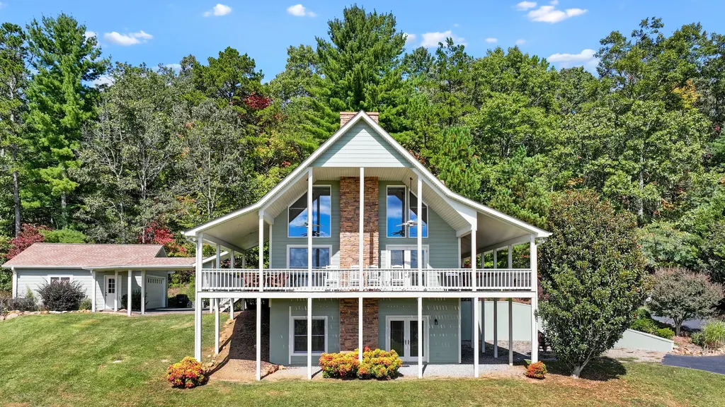 The front of the cabin in summer, green woods and blue sky behind it
